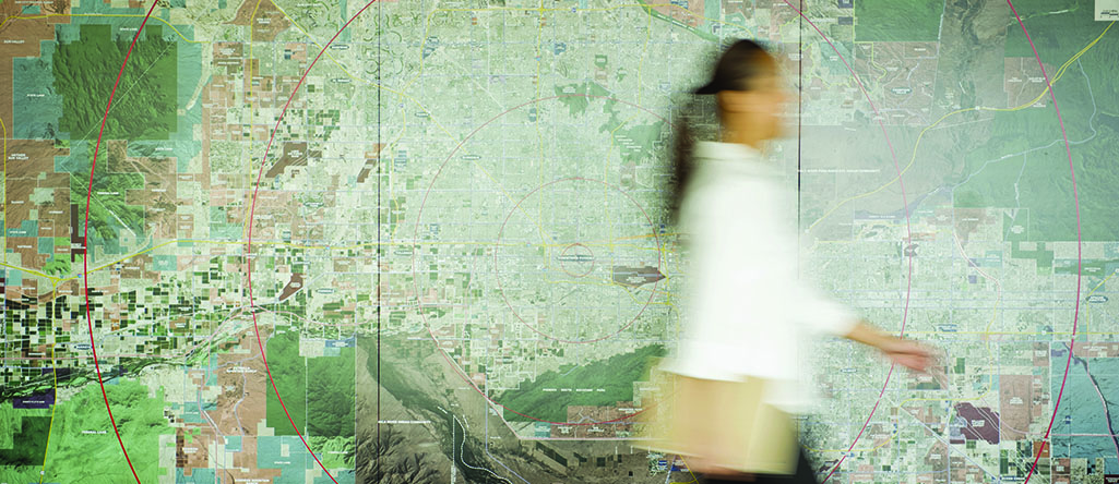 Mixed race businesswoman walking in conference table with map in background